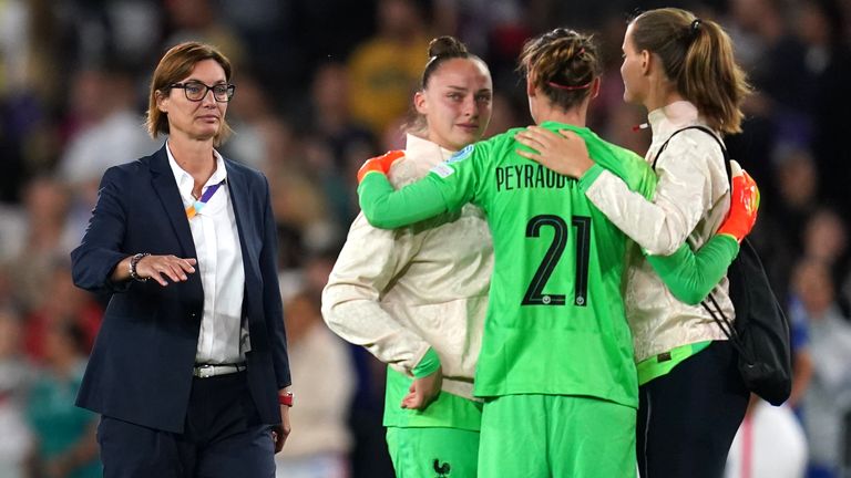 Corinne Diacre comforts her players after France's exit from Euro 2022