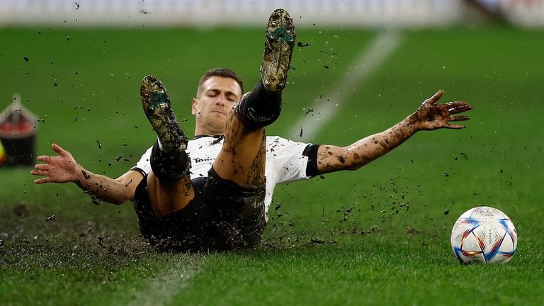 Man Utd&#39;s Diogo Dalot slides on a muddy Optus Stadium pitch against Aston Villa