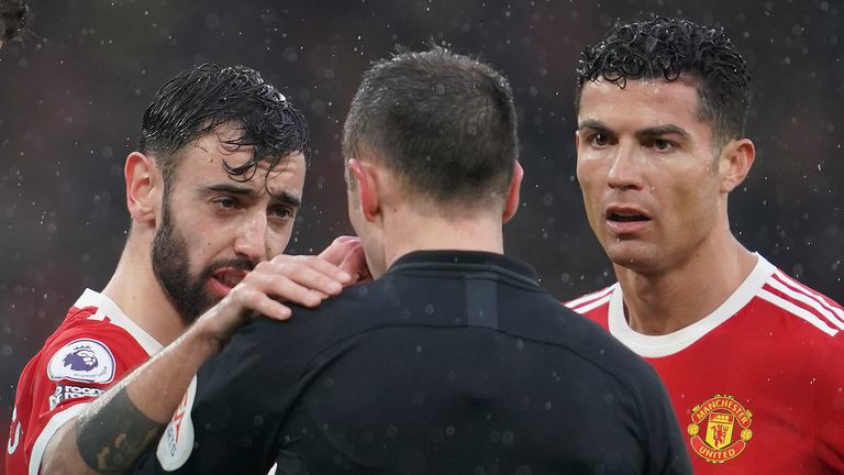 Manchester United&#39;s Cristiano Ronaldo, right, and Manchester United&#39;s Bruno Fernandes speak to the referee Stuart Attwell during the English Premier League soccer match between Manchester United and Southampton at Old Trafford stadium in Manchester, England, Saturday, Feb. 12, 2022. (AP Photo/Jon Super)