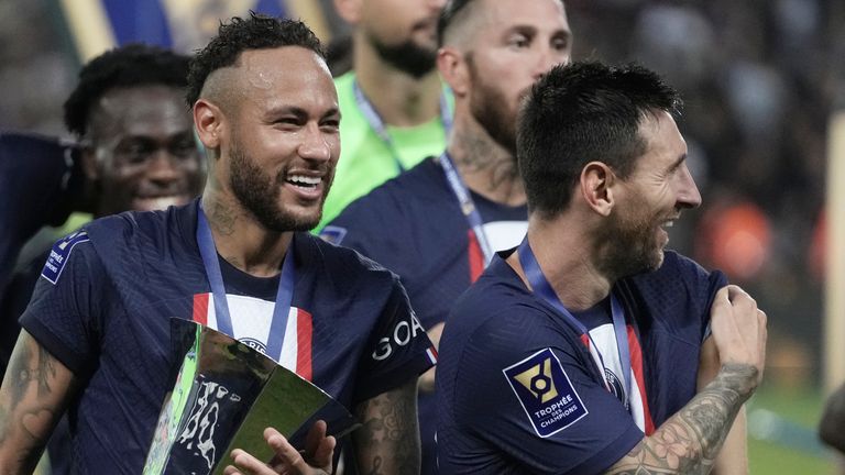 Neymar holds the trophy as he celebrate with Lionel Messi