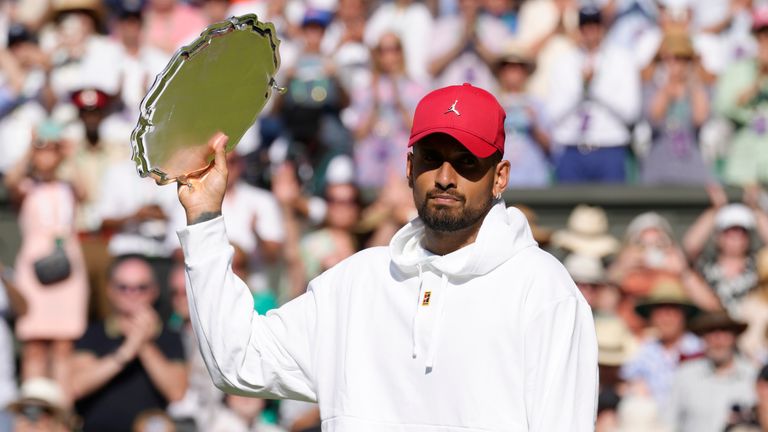 A dejected Nick Kyrgios holds his runners-up trophy after losing to Novak Djokovic in the final of Wimbledon