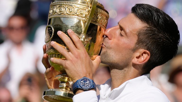 Novak Djokovic kisses the trophy after beating Nick Kyrgios in the Wimbledon men&#39;s final