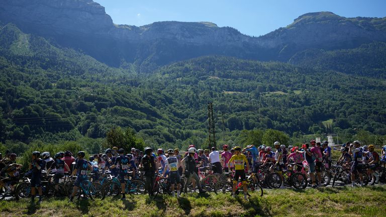 Riders in the peloton wait to restart after the race was stopped by climate activists on Stage 10