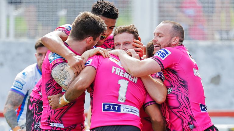 Bevan French is congratulated by his Wigan team-mates after scoring a try against Wakefield