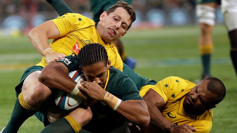 South Africa's Courtnall Skosan‚ front, scores a try as Australia's Bernard Foley, left, and teammate Kurtley Beale, defend during the Rugby Championship match between South Africa and Australia, at the Free State Stadium in Bloemfontein, South Africa, Saturday, Sept. 30, 2017. (AP Photo/Themba Hadebe)