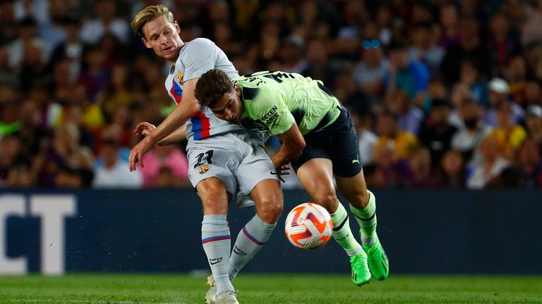 Barcelona's Frenkie de Jong, left, is challenged by Manchester City's Julian Alvarez during a charity friendly soccer match between Barcelona and Manchester City at the Camp Nou stadium in Barcelona, Spain, Wednesday, Aug. 24, 2022. (AP Photo/Joan Monfort)