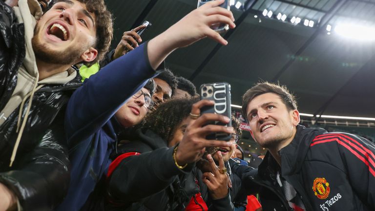 Harry Maguire of Manchester United takes a selfie with fans after the football match between Manchester United and Melbourne Victory at the Melbourne Cricket Ground, Australia, Friday, July 15, 2022.  (AP photo/Asanka Brendan Ratnayake)