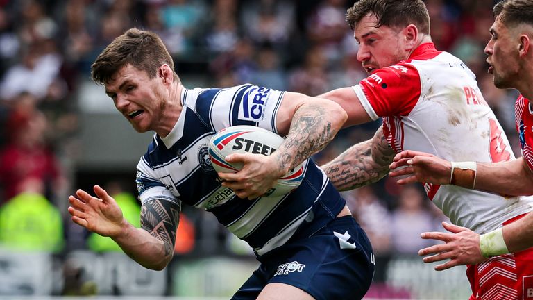Picture by Alex Whitehead/SWpix.com - 15/04/2022 - Rugby League - Betfred Super League: Round 8 - St Helens vs Wigan Warriors - Totally Wicked Stadium, St Helens, England - Wigan’s John Bateman is tackled by St Helens’ Mark Percival and Lewis Dodd.
