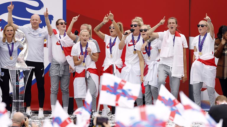 England players including Millie Bright (with mic) sing Sweet Caroline on stage during a fan celebration 