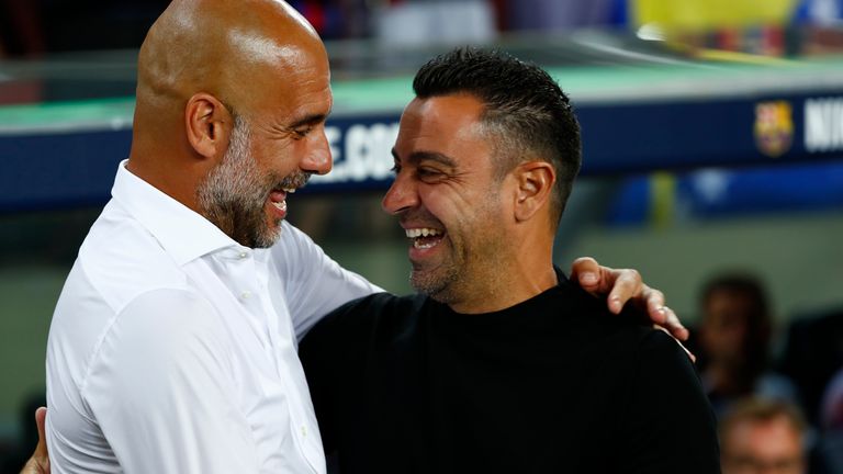 Barcelona head coach, Xavi Hernandez, right, looks great Manchester City head coach Pep Guardiola before the charity football match between Barcelona and Manchester City at the Camp Nou stadium in Barcelona, ​​​​Spain, Wednesday, August 24, 2022. (AP Photo / Joan Monfort)