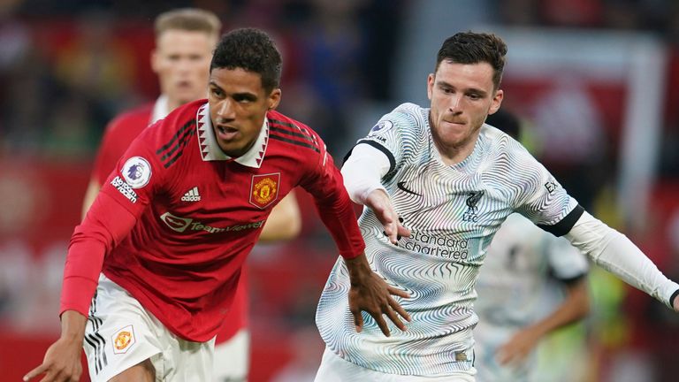 Raphael Varane del Manchester United desafía el balón con Andrew Robertson del Liverpool