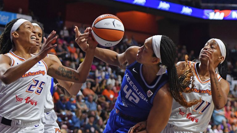 Connecticut Sun center Brionna Jones works for a rebound between Phoenix Mercury guard Jennie Simms and guard Shay Peddy during a WNBA basketball game Tuesday, Aug. 2, 2022, in Uncasville, Conn.