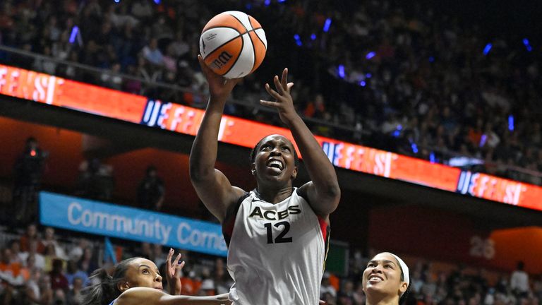 Las Vegas Aces' Chelsea Gray (12) goes up for a basket as Connecticut Sun's DeWanna Bonner, left, and Brionna Jones (42) defend during the second half in Game 4 of a WNBA basketball final playoff series, Sunday, Sept. 18, 2022, in Uncasville, Conn. (AP Photo/Jessica Hill)