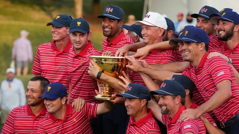 USA team captain Davis Love III and his team pose for a photo with the Presidents Cup trophy after defeating the International team in match play at the Presidents Cup golf tournament at the Quail Hollow Club, Sunday, Sept. 25, 2022, in Charlotte, N.C. (AP Photo/Chris Carlson)