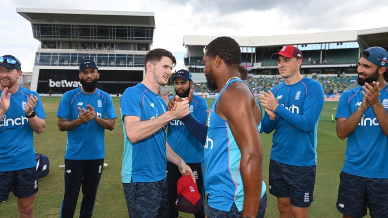 England's George Garton is presented with his cap by team-mate Chris Jordan ahead of the T20 International against the West Indies at Kensington Oval on January 26 in Barbados
