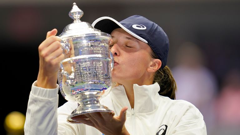 Iga Swiatek, of Poland, kisses the championship trophy after defeating Ons Jabeur, of Tunisia, in the women's singles final of the U.S. Open tennis championships, Saturday, Sept. 10, 2022, in New York. (AP Photo/Charles Krupa)
