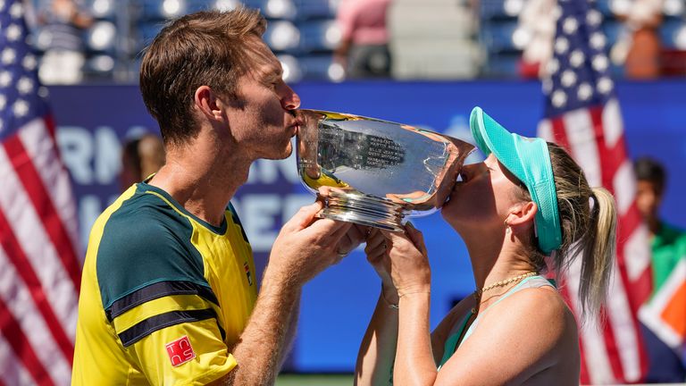 John Peers (z lewej) i Storm Sanders (Australia) całują trofeum mistrzowskie po wygraniu finału gry podwójnej mieszanej z Kirsten Flipkens (Belgia) i Edouardem Roger-Vasselin (Francja) na mistrzostwach US Open w sobotę 10 września, wygrana , 2022, w Nowym Jorku.  (Zdjęcie AP/Matt Rourke)