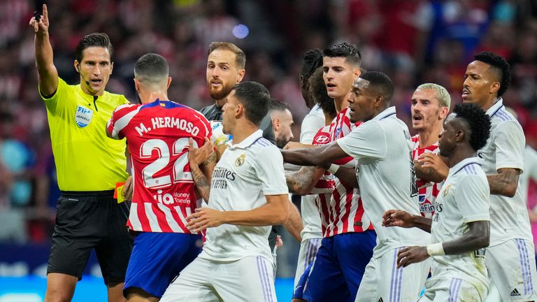 Tiesnesis Munuera Montero, pa kreisi, sarunājas ar spēlētājiem Spānijas La Liga futbola spēlē starp Madrides Atletico un Madrides Real 