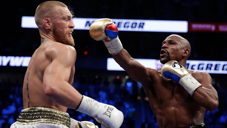 Floyd Mayweather Jr. hits Conor McGregor in a super welterweight boxing match Saturday, Aug. 26, 2017, in Las Vegas. (AP Photo/Isaac Brekken)