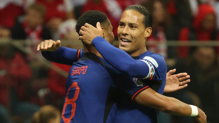 Netherlands Cody Gakpo, left, celebrates with the Netherlands Virgil van Dijk after scoring his team's first goal during the UEFA Nations League Soccer match between Poland and the Netherlands on Thursday, September 22, 2022 at the National Stadium in Warsaw, Poland.  (AP Photo/Michael DiJuk)