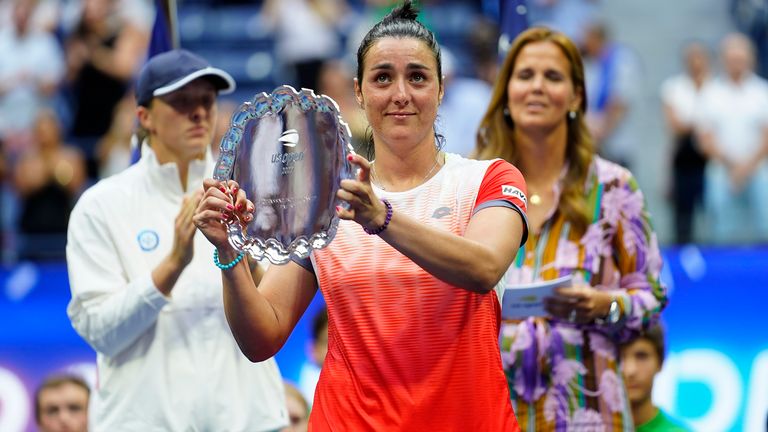 Ons Jabeur of Tunisia holds up the runner-up trophy after losing to Iga Swiatek of Poland in the women's singles final of the U.S. Open, Saturday, Sept. 10, 2022, in New York. (AP Photo/Matt Rourke)