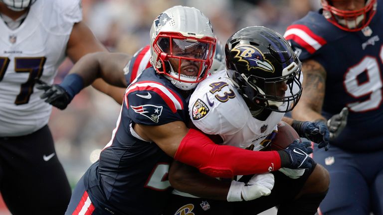 New England Patriots safety Adrian Phillips, left, tackles Baltimore Ravens running back Justice Hill, right, in the first half of an NFL football game, Sunday, Sept. 25, 2022, in Foxborough, Mass.