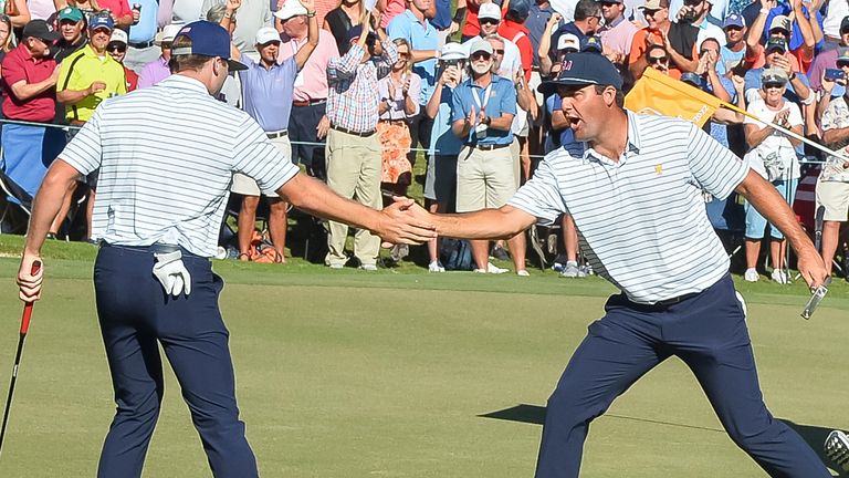 Scottie Scheffler congratulates Sam Burns on making a putt on the 15th hole during the Presidents Cup at Quail Hollow Club