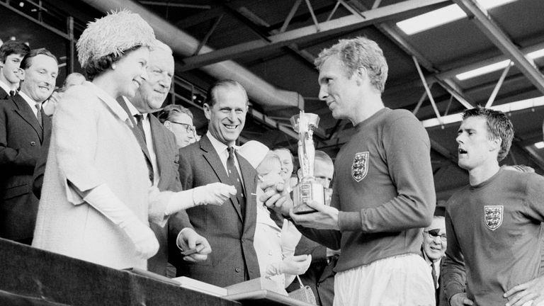 Bobby Moore holding the Jules Rimet Trophy, collected from Queen Elizabeth II , after leading his team to victory in the World Cup final over West Germany in 1966