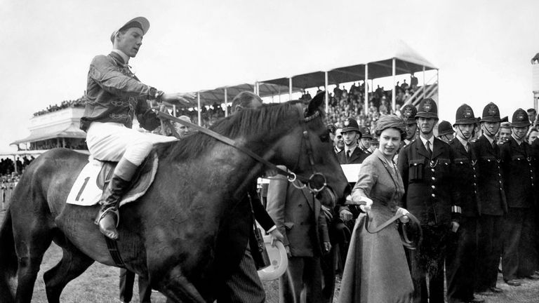 Her Majesty The Queen leads in Carrozza, with Lester Piggott in the saddle, after victory in the 1957 Oaks
