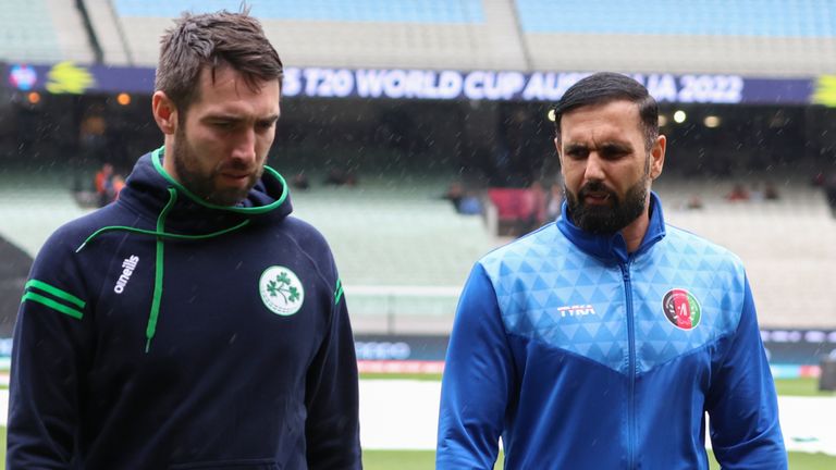 Ireland's captain Andrew Balbirnie, left, and Afghanistan's captain, Mohammad Nabi walk from the field after their match was abandoned due to rain at the T20 World Cup cricket in Melbourne, Australia, Friday, Oct. 28, 2022. (AP Photo/Asanka Brendon Ratnayake)