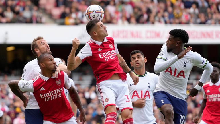 Arsenal's Granit Xhaka, centre, heads the ball past Tottenham's Emerson Royal, right