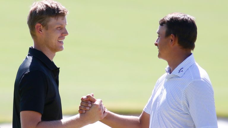 Cam Davis, left, of Australia, shakes hands with Christiaan Bezuidenhout, of South Africa, after finishing round two of the Shriners Children's Open golf tournament on the ninth hole at TPC Summerlin, Friday, Oct. 7, 2022, in Las Vegas. (AP Photo/Ronda Churchill)