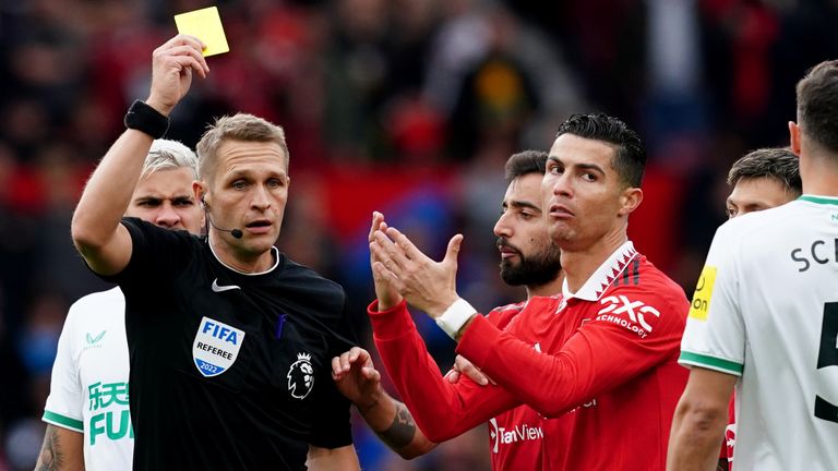 Cristiano Ronaldo receives a yellow card from referee Craig Pawson