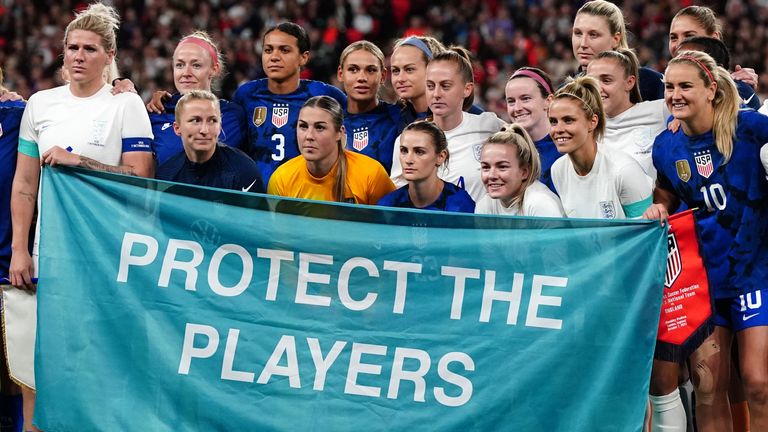 Inggris dan AS berdiri bersama di tengah lingkaran dengan spanduk bertuliskan "Lindungi Pemain" sebagai bentuk solidaritas bagi para korban pelecehan seksual menjelang pertandingan persahabatan internasional di Stadion Wembley, London.  Tanggal pengambilan gambar: Jumat 7 Oktober 2022.