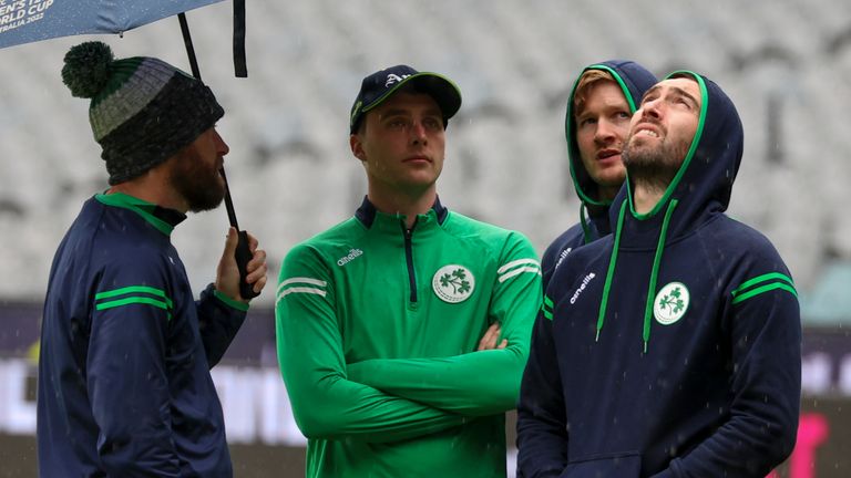 Ireland players stand on the field as they wait for the rain to stop ahead of their T20 World Cup cricket match against Afghanistan is delayed in Melbourne, Australia, Friday, Oct. 28, 2022. (AP Photo/Asanka Brendon Ratnayake)