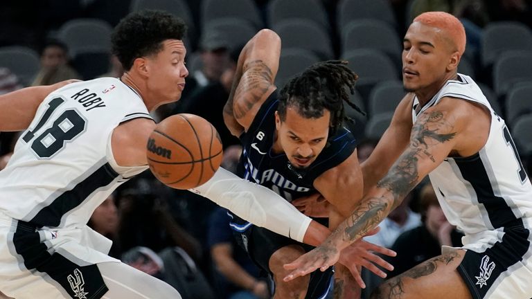 Orlando Magic guard Cole Anthony, centre, is robbed of possession by San Antonio Spurs forwards Isaiah Roby and Jeremy Sochan