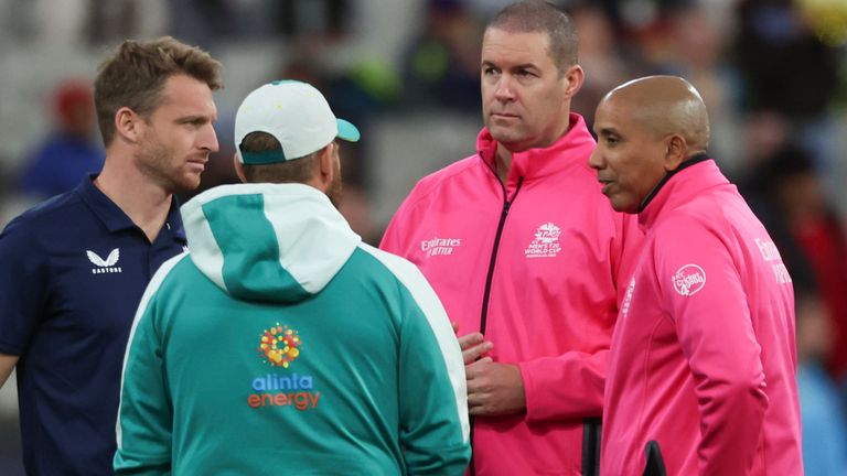 Umpires Joel Wilson, right and Chris Brown talk with rival captain's England's Jos Buttler, left, and Australia's Aaron Finch as rain delays the start to the T20 World Cup cricket match between Australia and England in Melbourne, Australia, Friday, Oct. 28, 2022. (AP Photo/Asanka Brendon Ratnayake)