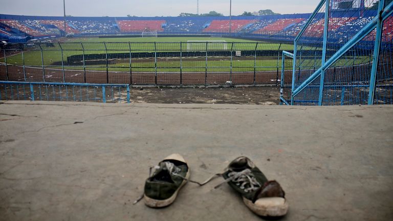 A pair of sneakers are trampled in the stands of Kanjuruhan Stadium following a deadly stampede during a football match, in Malang, East Java, Indonesia, Sunday, Oct. 2, 2022. Panic during a at an Indonesian football match after police fired tear gas to disperse fans the invasion of the pitch left more than 100 people dead, most trampled to death, police said on Sunday.  (AP Photo/Hendra Permana)