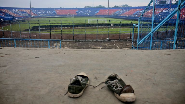 Un par de tenis pisoteados en las gradas del estadio Kanjuruhan luego de una estampida mortal en un partido de fútbol, ​​en Malang, Java Oriental, Indonesia, el domingo 2 de octubre de 2022. Pánico en un partido de fútbol de Indonesia después de que la policía disparó gases lacrimógenos para dispersar a los hinchas que invadían la cancha dejó más de 100 muertos, la mayoría pisoteados, dijo la policía el domingo.  (Foto AP/Hendra Permana)