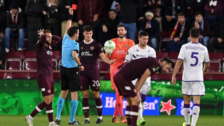 Referee Erik Lambrechts shows Hearts' Lewis Neilson a red card