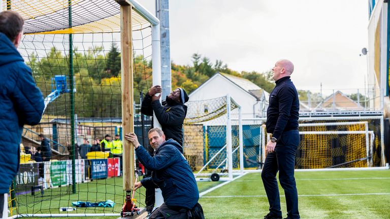Livingston boss David Martindale helps to adjust the crossbar to the correct height pre-match