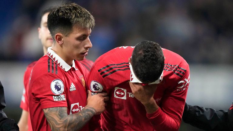 Raphael Varane covers his face after injury forces him off the pitch in Manchester United&#39;s visit to Chelsea