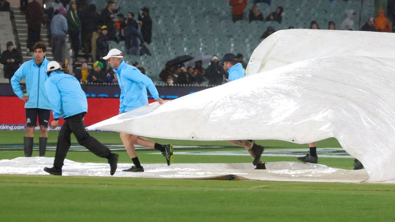 Ground staff place covers over the wicket as rain causes the cancelation of the T20 World Cup cricket match between Australia and England in Melbourne, Australia, Friday, Oct. 28, 2022. (AP Photo/Asanka Brendon Ratnayake) 