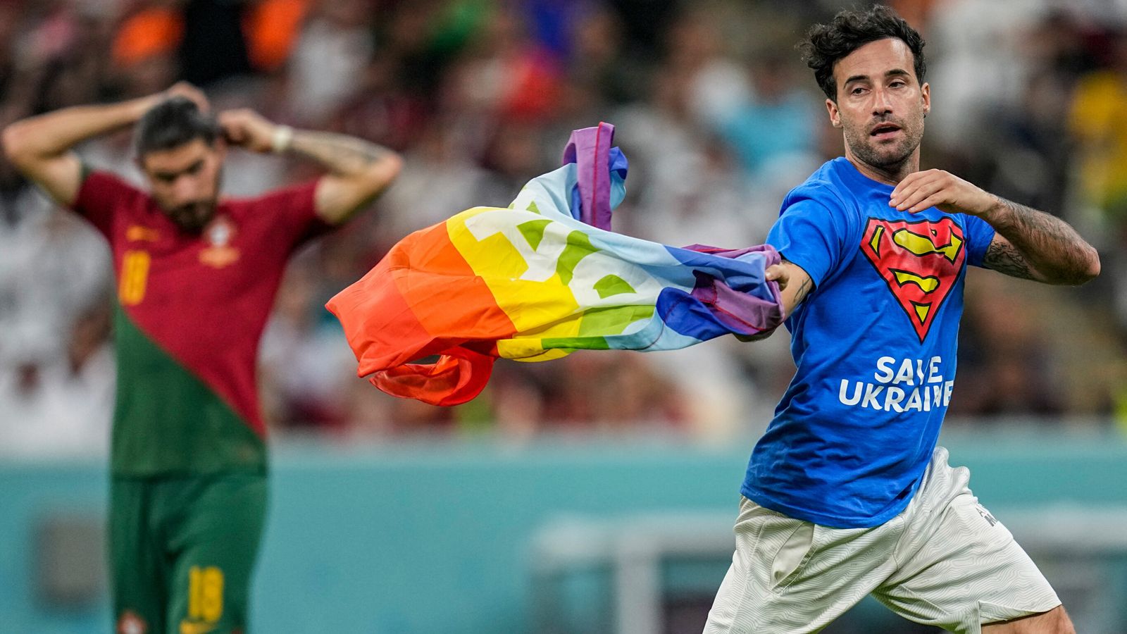 World Cup pitch invader carries rainbow flag onto grass during Portugal vs Urugu..