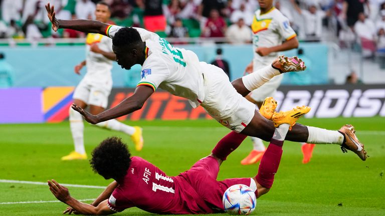 Qatar's Akram Afif goes down under a challenge from Senegal's Ismaila Sarr