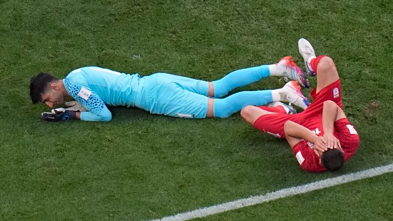 Iran&#39;s Majid Hosseini (right) and Alireza Beiranvand after a clash of heads in the first half