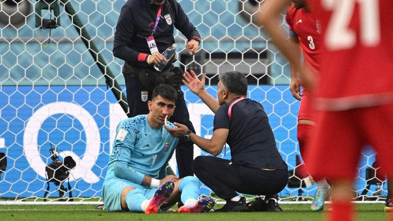 Il portiere iraniano Alireza Beiranvand riceve cure dopo una collisione alla testa con un compagno di squadra