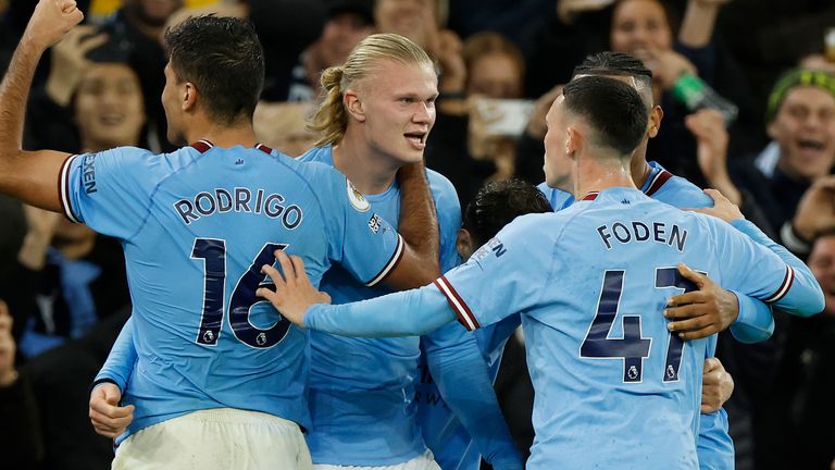 Erling Haaland is mobbed after scoring an injury-time penalty for Manchester City
