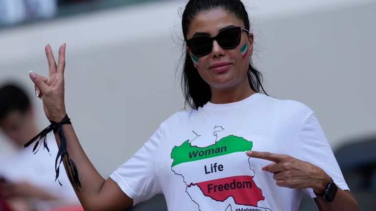 Seorang penggemar mengenakan pita hitam dan tulisan T-shirt "Wanita, Hidup, Kebebasan" untuk mengenang Mahsa Amini, yang meninggal saat dalam tahanan polisi di Iran