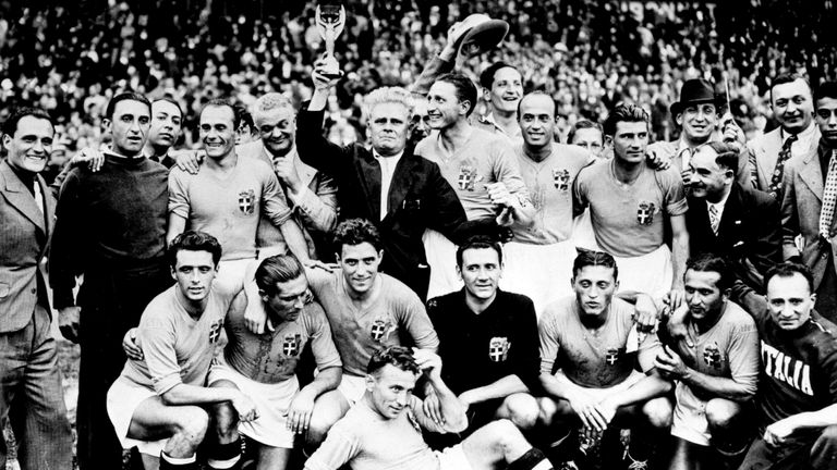 Italy's coach Vittorio Pozzo and players celebrate with the Jules Rimet trophy in 1938